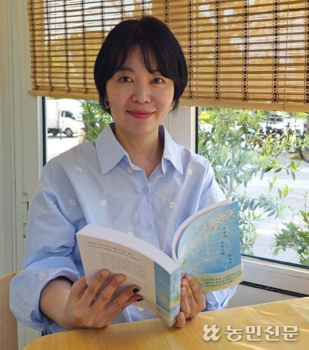 어머니와의 존엄사 여정을 책으로 낸 남유하 작가. 책 ‘오늘이 내일이었으면 좋겠다’를 들고 웃고 있다.