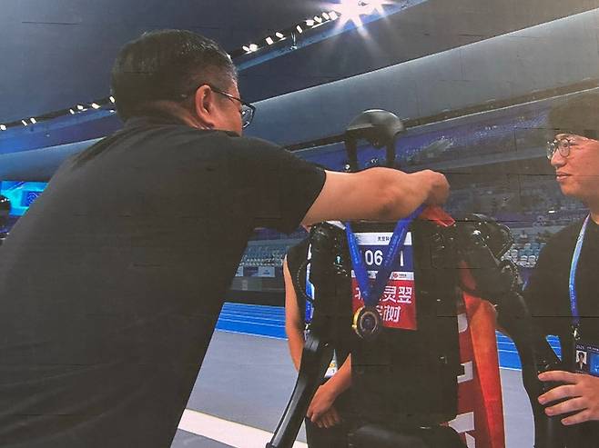로봇 1천500ｍ 달리기 우승자 '링이과학기술'팀     (베이징=연합뉴스) 정성조 특파원 = 15일 오전 중국 베이징 '세계 휴머노이드 로봇 운동회' 1천500ｍ 달리기에서 우승을 차지한 유니트리 자회사 링이과학기술팀의 로봇이 메달을 수여받고 있다. 2025.8.15 xing@yna.co.kr