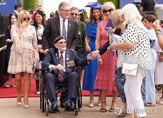 2차대전 참전 용사의 휠체어를 미는 스타머 총리 [로이터 연합뉴스 재판매 및 DB 금지]