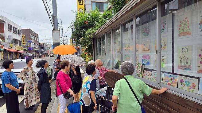 ▲ 제80주년 광복절을 기념해 열린 '고맙다 대한민국' 전시회가 진행 중인 수원시 세류2동 1007-15 로드 갤러리에서 시민들이 작품을 감상하고 있다.