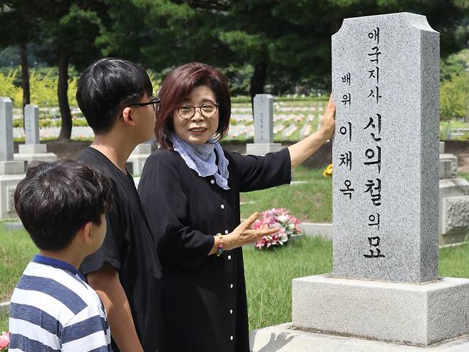 독립운동에 헌신한 신의철 애국지사의 딸 신미자(69) 씨가 8월 15일 국립대전현충원에서 13살 9살 두 손자에게 80여 년 전 증조할아버지의 생애에 대해 설명하고 있다. &nbsp;(사진=임병안 기자)