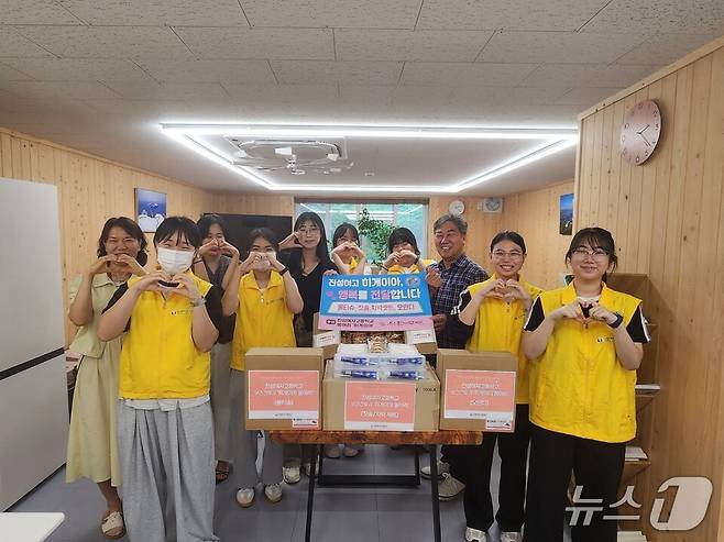 '히게이아' 동아리 학생들이 문수종합사회복지관을 찾아 후원물품을 전달한 뒤 기념사진을 찍고 있다. (전남도교육청 제공, 재판매 및 DB 금지)/뉴스1