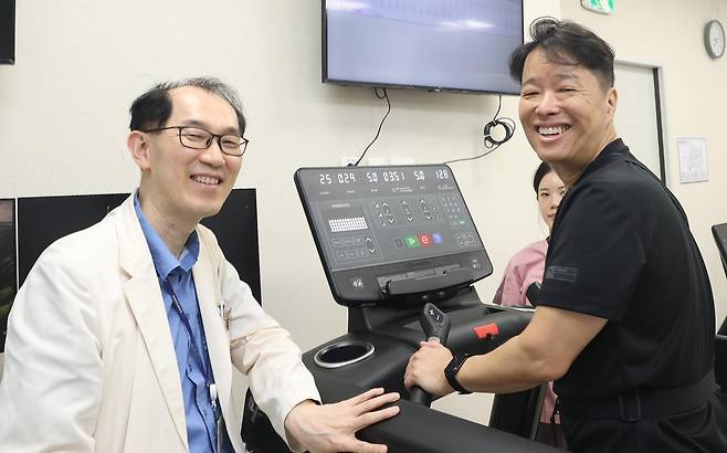 김정언 씨(오른쪽)는 급성 심근경색 1차 시술 이후 심장 재활훈련을 꾸준히 받아 재발 위험을 낮추고 일찍 회복하는 데 성공했다. 김 씨가 성지동 삼성서울병원 순환기내과 교수와 함께 심장 재활훈련을 하고 있다. 삼성서울병원 제공