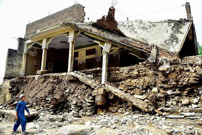현지시각 16일 기습 폭우로 인한 홍수 피해를 입은 파키스탄 북서부 카이버파크툰크와주 부네르 지구에 집이 무너져 있다. AFP/연합뉴스