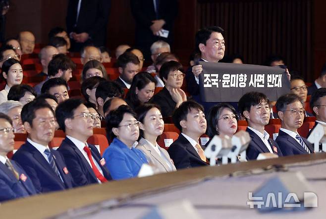 [서울=뉴시스] 최동준 기자 = 안철수 국민의힘 당대표 후보가 15일 서울 종로구 세종문화회관에서 열린 제80주년 광복절 경축식에서 조국, 윤미향 사면 반대 피켓을 들고 있다. 2025.08.15. photocdj@newsis.com