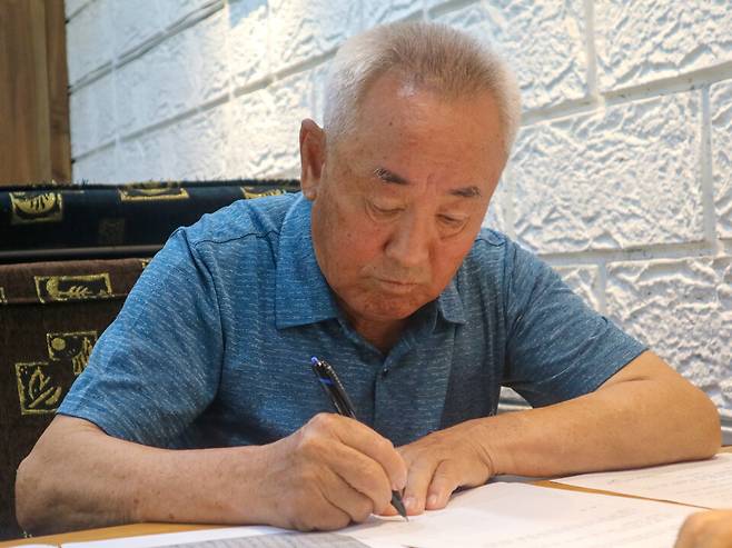 ▲강제동원 피해자 유족 김경선(88세)씨가 외로이 세상을 떠난 아버지의 기억을 떠올리며 조심스레 글을 써 내려가고 있다./사진제공=경기도