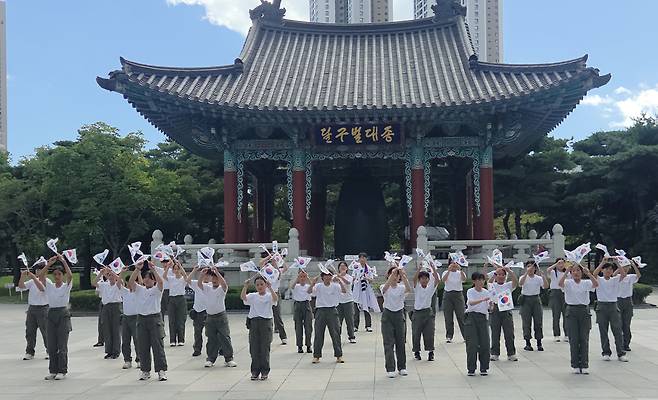 어린이독도의용수비대원들이 대한민국 광복의 상징색 흰색과 검은 색 옷을 입고 달구벌 대종 앞에서 플래쉬몹을 하고 있다. /울릉군가족센터