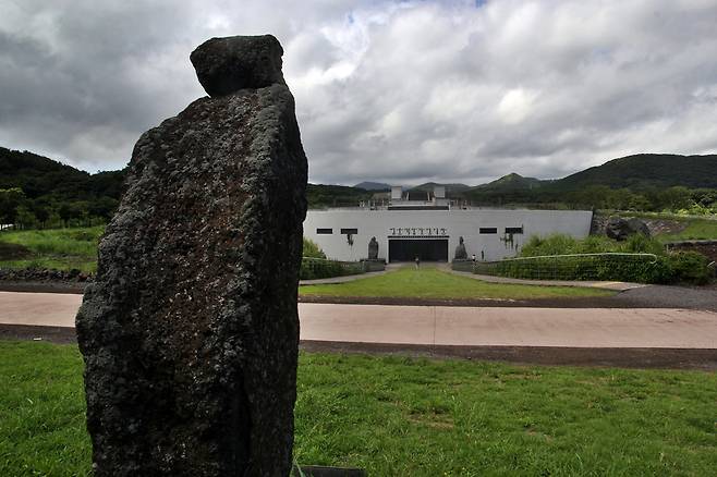 돌문화공원 기획자 백운철 선생이 만든 본인 모습의 석상이 전시관을 바라보듯 세워져 있다. ⓒ제주의소리