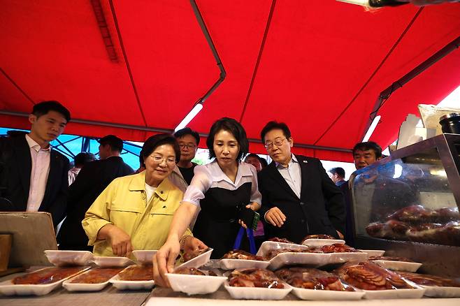 이재명 대통령과 김혜경 여사가 17일 서울 은평구 연서시장을 방문해 족발을 고르고 있다. /대통령실 제공