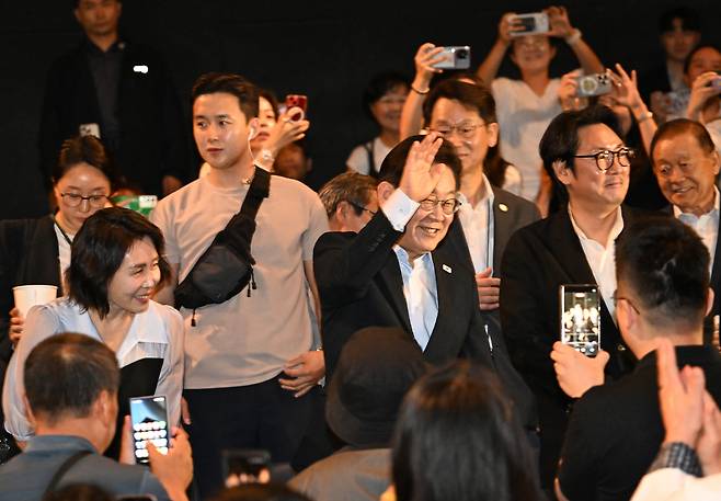 이재명 대통령과 부인 김혜경 여사가 17일 서울시내 한 영화관에서 ‘독립군:끝나지 않은 전쟁’ 영화 관람을 위해 입장하며 관람객들에게 인사하고 있다. 대통령실사진기자단