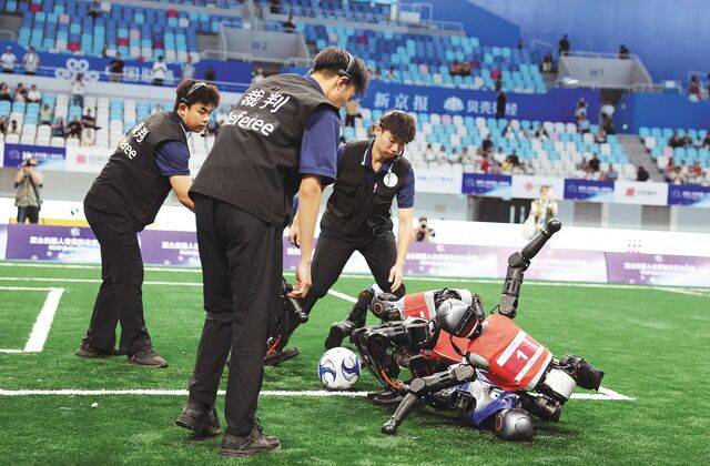 16일 진행된 5대 5 축구 경기 중 로봇들이 충돌하며 쓰러지자 심판들이 모여든 모습. 로이터연합뉴스