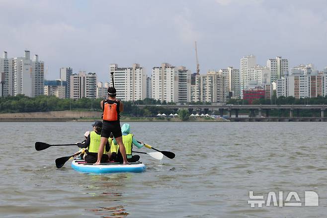 [서울=뉴시스] 권창회 기자 = 17일 서울 마포구 난지한강공원에서 시민들이 2025 한강페스티벌의 일환인 '카약 타Go, 패들보드 타Go' 행사를 즐기고 있다. 2025.08.17. kch0523@newsis.com