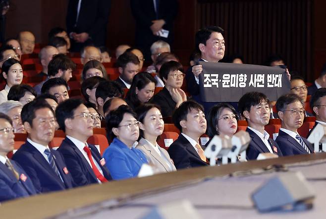 국민의힘 안철수 의원이 지난 15일 서울 세종문화회관에서 열린 80주년 광복절 경축식에서 이재명 대통령이 경축사를 마치고 자리로 향할 때 ‘조국·윤미향 사면 반대’ 문구가 적힌 펼침막을 들어 보이고 있다. 연합뉴스
