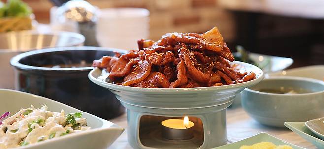 강진군 ‘마량 미항횟집거리’의 대표 메뉴인 싱싱한 회 한 상과 ‘병영 돼지불고기거리’의 대표 메뉴인 매콤한 양념과 불맛이 어우러진 연탄불 돼지 불고기. <강진군 제공>