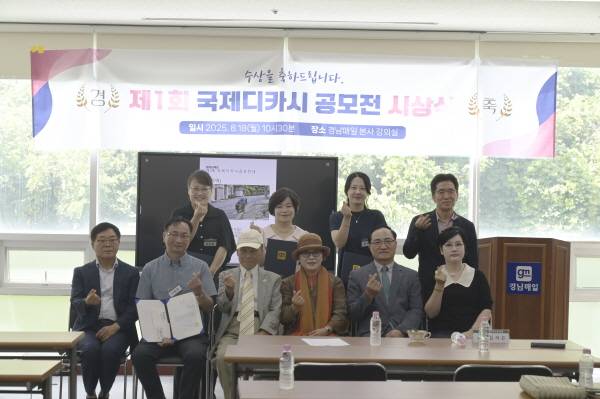 제1회 국제 디카시 공모전 수상자들과 내빈들이 손하트를 하며 기념촬영을 하고 있다.