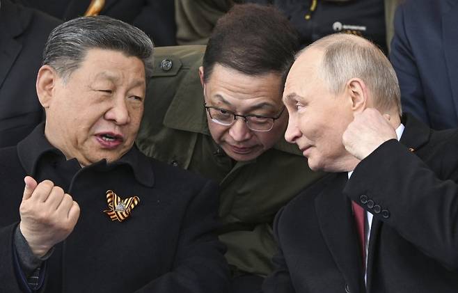 블라디미르 푸틴(오른쪽) 대통령과 시진핑 중국 국가주석이 지난 6월 9일(현지 시간) 러시아 모스크바 붉은광장에서 열린 제2차 세계대전 승리 80주년(전승절) 기념 열병식을 지켜보면서 얘기를 나누고 있다. AP·뉴시스