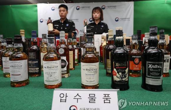 지난 5일 서울 강남구 서울본부세관에서 열린 초고가 위스키 밀수입 및 탈세 행위 고소득자 검거 실적 브리핑에서 직원들이 압수물품을 공개하고 있다. [사진=연합뉴스]