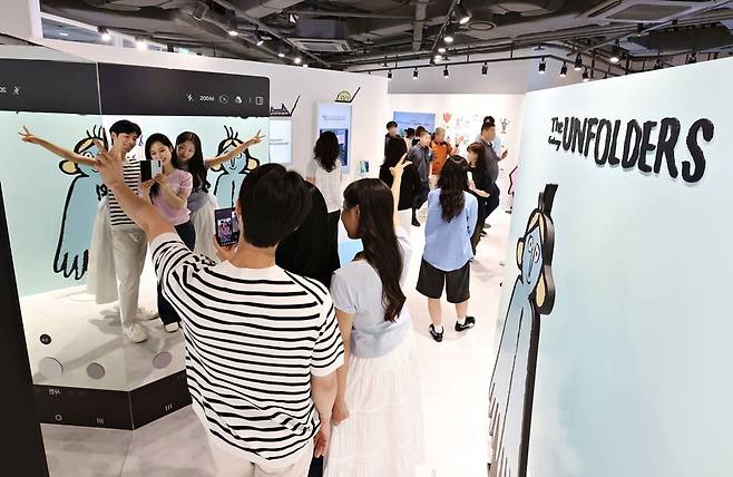 서울 코엑스 '더 갤럭시 언폴더스' 체험존 방문객들이 갤럭시Z폴드7을 이용해 아티스트 '장 줄리앙'의 캐릭터와 함께 인증샷을 찍고 있다. 사진=삼성전자