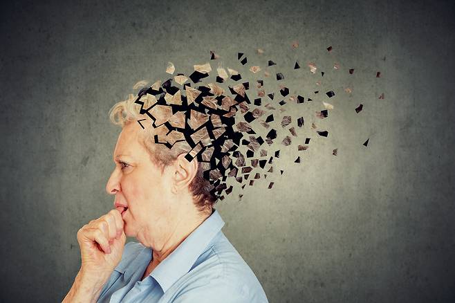 Memory loss due to dementia. Senior woman losing parts of head feeling confused as symbol of decreased mind function. [shutterstock]