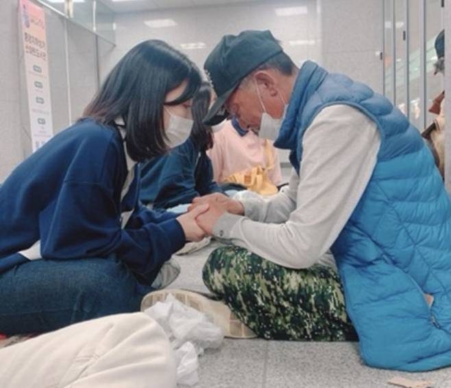 경기도 성남청운교회 성도들이 '나그네 사역' 중 노숙인에게 도시락을 전한 뒤 손을 잡고 기도하는 모습. 이 목사 제공