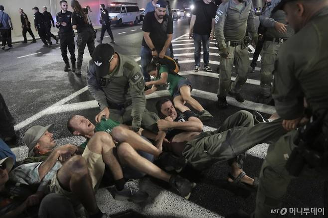 [예루살렘=AP/뉴시스] 17일(현지 시간) 예루살렘 인근에서 이스라엘 경찰이 도로를 막고 농성 중인 시위대를 해산시키고 있다. 시위대는 정부의 가자지구 점령 결정 철회와 하마스에 억류된 인질들의 즉각적인 석방을 요구하며 시위를 벌였다. 2025.08.18. /사진=민경찬