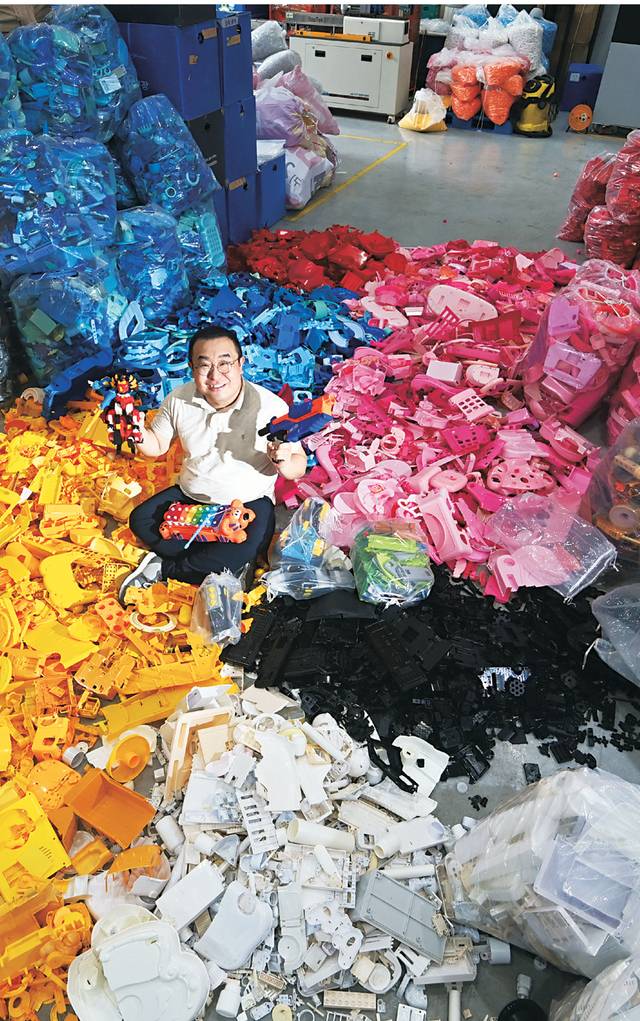이채진 코끼리공장 대표가 울산 울주군 웅촌면 코끼리공장에서 장난감 부품 속에 파묻힌 채 아이들에게 나눠줄 장난감을 들어 보이고 있다.   윤성호 기자