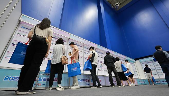 한 일자리 박람회에서 구직자들이 채용공고 게시대를 살펴 보고 있다.  [연합]