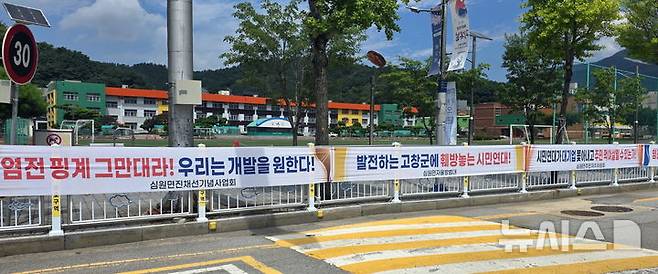 [고창=뉴시스] 김종효 기자 = 18일 고창군초등학교 앞 도로담장에 고창종합테마파크 건립 찬성 및 반대 중단요구 현수막이 걸려 있다. 2025.08.18. kjh6685@newsis.com