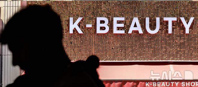 [서울=뉴시스] 정병혁 기자 = 27일 서울 중구 명동을 찾은 외국인 여행객들이 화장품 매장 앞을 지나고 있다.지난해 국내 화장품 생산액이 17조원으로 사상 최대 실적을 기록했다. 화장품 수출은 102억 달러로 독일을 제치고 세계 3위로 올라섰다. '2024년 화장품 생산·수출·수입 통계'에 따르면 지난해 국내 화장품 생산 실적은 전년(14조5102억원) 대비 20.9% 증가한 17조5426억원을 기록했다. 지난해 수출실적은 전년(85억 달러)보다 20.3% 증가한 102억 달러(약 13조8819억원)로 집계돼 사상 최대 실적을 나타냈다. 2025.05.27. jhope@newsis.com