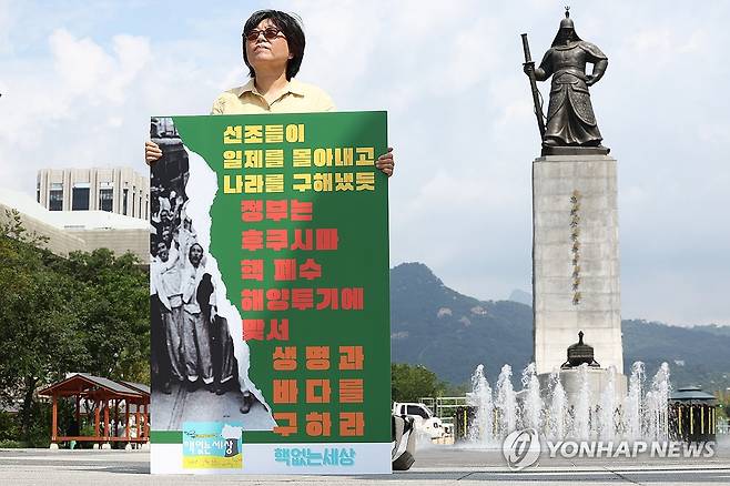 후쿠시마 오염수 해양투기 반대 시위 (서울=연합뉴스) 김성민 기자 = 시민단체 환경보건센터 등이 18일 오전 서울 종로구 광화문광장 이순신 장군 동상 앞에서 연 '후쿠시마 오염수 해양투기 반대 시위'에서 한 참가자가 손팻말을 들고 있다. 2025.8.18 ksm7976@yna.co.kr