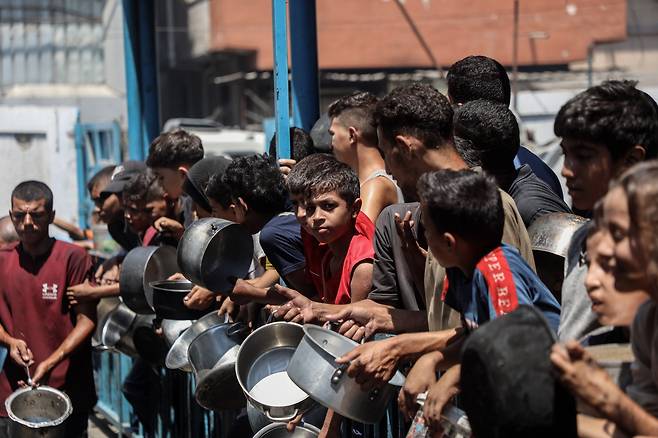 2025년 8월 18일 가자시티 한 유통 센터에서 무료 식량을 받기 위해 기다리는 팔레스타인 피난민들./연합뉴스