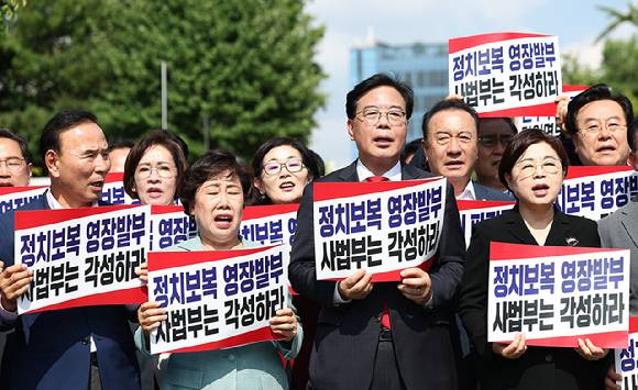 국민의힘 송언석 비상대책위원장 겸 원내대표를 포함한 의원들이 18일 서울 서초구 서울중앙지방법원 앞에서 열린 현장비상의원총회에서 구호를 외치고 있다. [사진=연합뉴스]