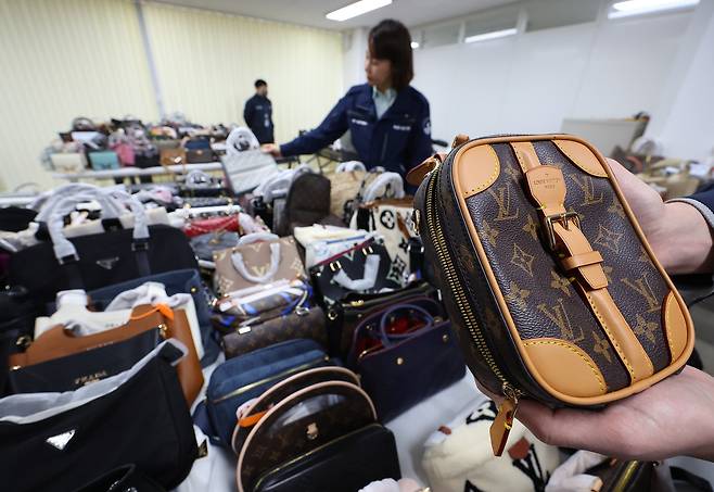 지난 2월 20일 서울 중구 시청 남산 별관에서 서울시 민생사법경찰국(민사국) 관계자들이 명동 일대에서 외국인을 상대로 위조 상품을 판매한 일당 2명으로부터 압수한 가방 등을 정리하고 있다. 연합뉴스