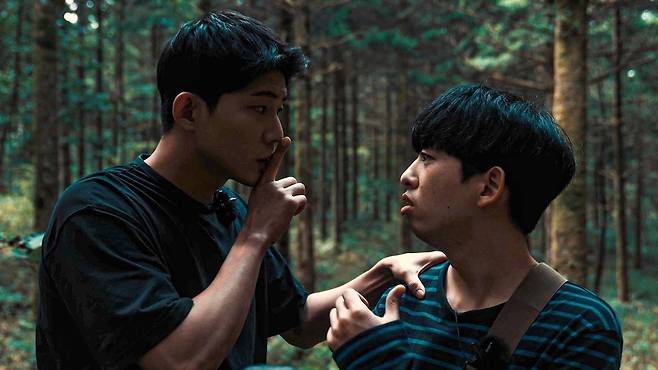 ·<THE 자연인>에서 귀신을 쫓는 유튜버 인공(왼쪽·변재신)이 친구 병진(오른쪽·정용훈)의 어깨를 한 손으로 잡고 조용히 하라는 신호를 보내고 있다. 스톤워크 제공