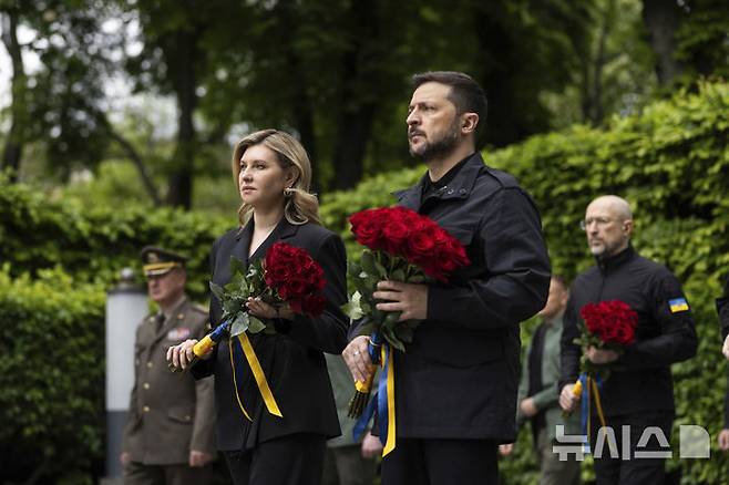 [키이우=AP/뉴시스] 러시아는 19일(현지 시간) 우크라이나 전사자 시신 1000구 이상을 우크라이나로 인도했다. 볼로디미르 젤렌스키 우크라이나 대통령 부부가 지난 5월 8일 키이우의 제2차 세계대전 참전용사 추모 공원에서 열린 전승 80주년 기념식에 참석해 무명용사 추모비에 헌화하고 있다. 2025.08.19.