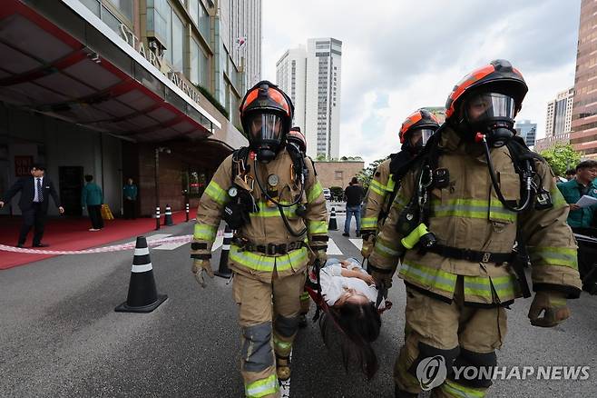 통합방위 능력향상을 위한 관계기관 합동훈련 (서울=연합뉴스) 이동해 기자 = 19일 서울 중구 롯데호텔에서 열린 을지연습 연계 통합방위능력 향상 관계기관 합동훈련에서 대원들이 드론을 이용한 테러 공격과 화재 발생 상황을 가정해 훈련을 진행하고 있다. 2025.8.19 eastsea@yna.co.kr