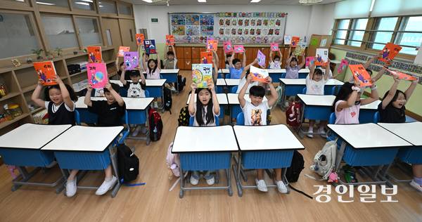 20일 오전 수원시 팔달구 매산초등학교에서 여름방학을 마치고 개학한 3학년 학생들이 교과서를 들어 보이며 환하게 웃고 있다. 2025.8.20 /최은성기자 ces7198@kyeongin.com