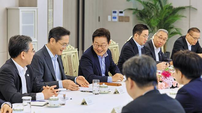 이재명 대통령이 19일 서울 용산 대통령실 청사에서 열린 미일 순방 동행 경제단체 및 기업인 간담회에서 이재용 삼성전자 회장을 비롯한 참석자들과 대화하고 있다./대통령실