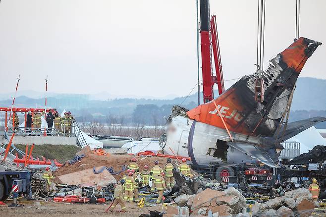 제주항공 여객기 참사 엿새째인 3일 오후 전남 무안국제공항 참사 현장에서 사고 기체의 꼬리 부분이 타워크레인에 의해 인양되고 있다./뉴스1