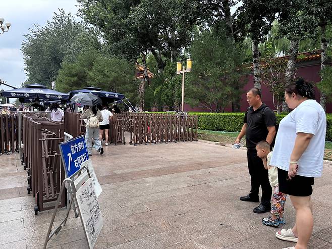 지난 19일 오후 톈안먼 인근 보행로에서 한 가족이 통행 금지 안내문을 읽고 있다. 톈안먼 입장권을 예매하지 않으면 이곳을 지날 수 없어 먼 길로 우회해야 한다. /베이징=이은영 특파원
