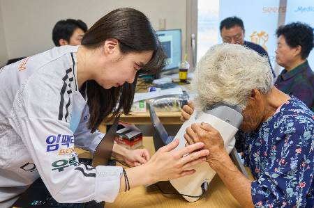 대부도 주민이 AI(인공지능) 실명질환 진단 솔루션 ‘위스키’와 안저카메라 ‘옵티나 제네시스’를 활용해 안저 상태를 확인하고 있다./사진=대웅제약