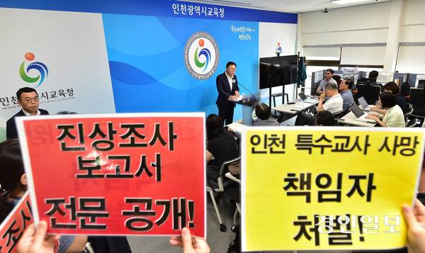 21일 오전 인천시교육청 브리핑룸에서 유석형 정책기획조정관이 특수교사 사망 사건 진상조사 보고서 공개 절차 등을 설명하는 가운데 교원단체 관계자들이 보고서 전문 공개를 촉구하는 피켓을 들고 있다. 2025.8.21 /조재현기자 jhc@kyeongin.com