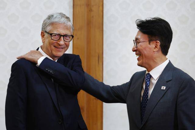 김민석 국무총리가 21일 빌 게이츠 게이츠재단 이사장과의 오찬 회담을 앞두고 게이츠 이사장의 어깨에 묻은 먼지를 털어주고 있다. 청사사진기자단