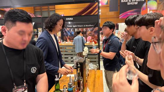 Fans line up at Kimchangsoo Whiskey's booth to try his whiskeys at Seoul Bar & Spirits Show held on July 24. [WOO JI-WON]