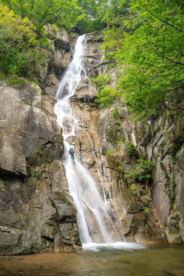 강원도 홍천군 내촌면 와야리 백암산 가령폭포를 찾은 암벽등반 애호가가 안전 로프를 타고 세찬 물줄기 속을 하강하며 무더위를 식히고 있다.