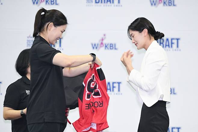 박지수(오른쪽)가 박정은 BNK 감독으로부터 유니폼을 전달받고 있다. /사진=WKBL 제공