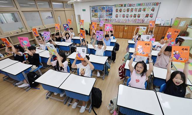 경기 수원시 매산초등학교 3학년 1반 교실에서 개학을 맞은 아이들이 새로 받은 교과서를 들어 보이고 있다. (사진=이지은 기자)