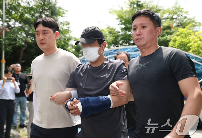 22일 오후 경기 용인시 기흥구 용인서부경찰서로 지인을 살해하고 도주한 30대 남성 A 씨가 압송되고 있다.  2025.8.22/뉴스1 ⓒ News1 김영운 기자