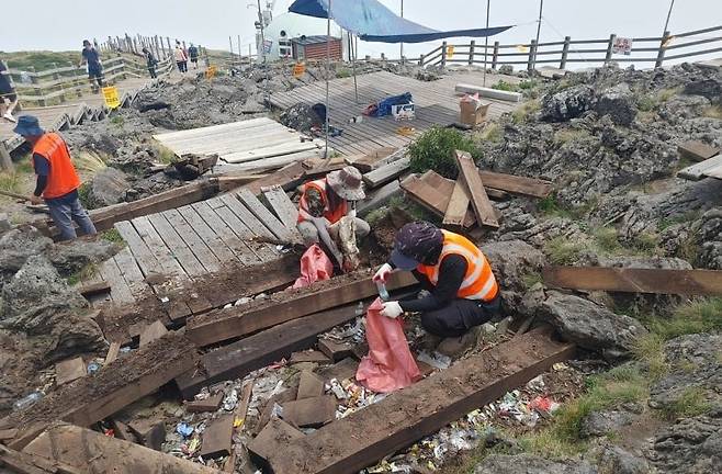 한라산국립공원 관계자들이 백록담 주변 나무테크 교체 과정에서 나온 쓰레기를 수거하고 있다./한라산국립공원관리소