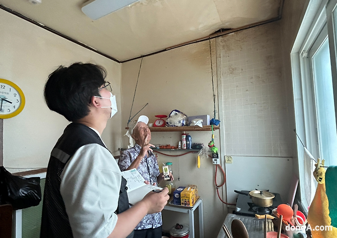 침수 피해로 생긴 대형 구멍, 굿피플 부울경지부 이옥길 팀장이 천장을 점검하며 김영태 할아버지의 이야기에 귀 기울이고 있다. (사진=최강주 기자 gamja@donga.com)